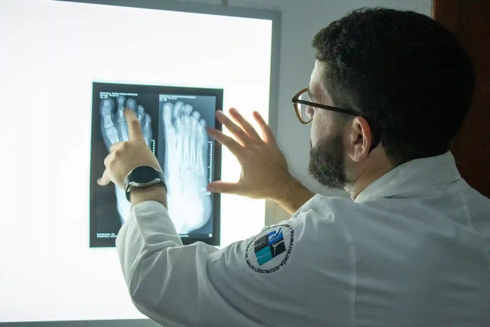El Dr. Isaac Pacheco señala una radiografía de pie en el negatoscopio