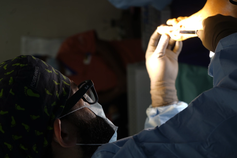El Dr. Isaac Pacheco revisa a contraluz una radiografía de pie durante una cirugía